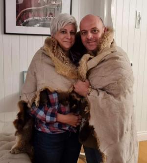 Laura and Laurent Fontaine pose in a possum skin cloak that was gifted to author John Danalis. Credit: Laura Fontaine