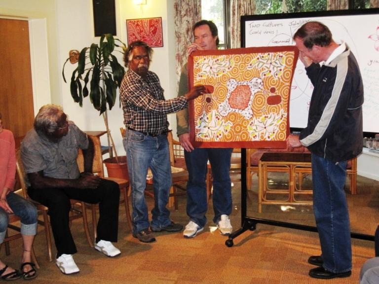Australian Indigenous leader Geoffrey Shannon from Tennant Creek, Northern Territory, presents a painting by his wife to Rob Wood and Jabez Phillpot for the ‘Armagh’ community.